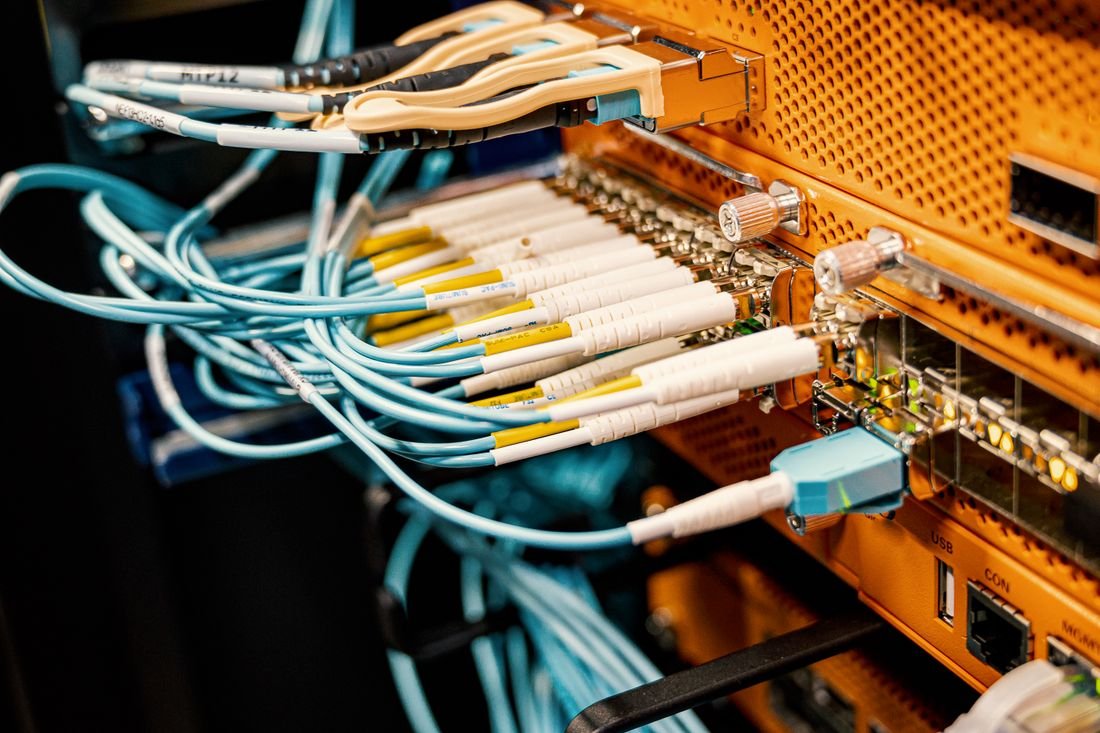 Cables de fibra óptica conectados a un equipo de red, infraestructura del internet de fibra