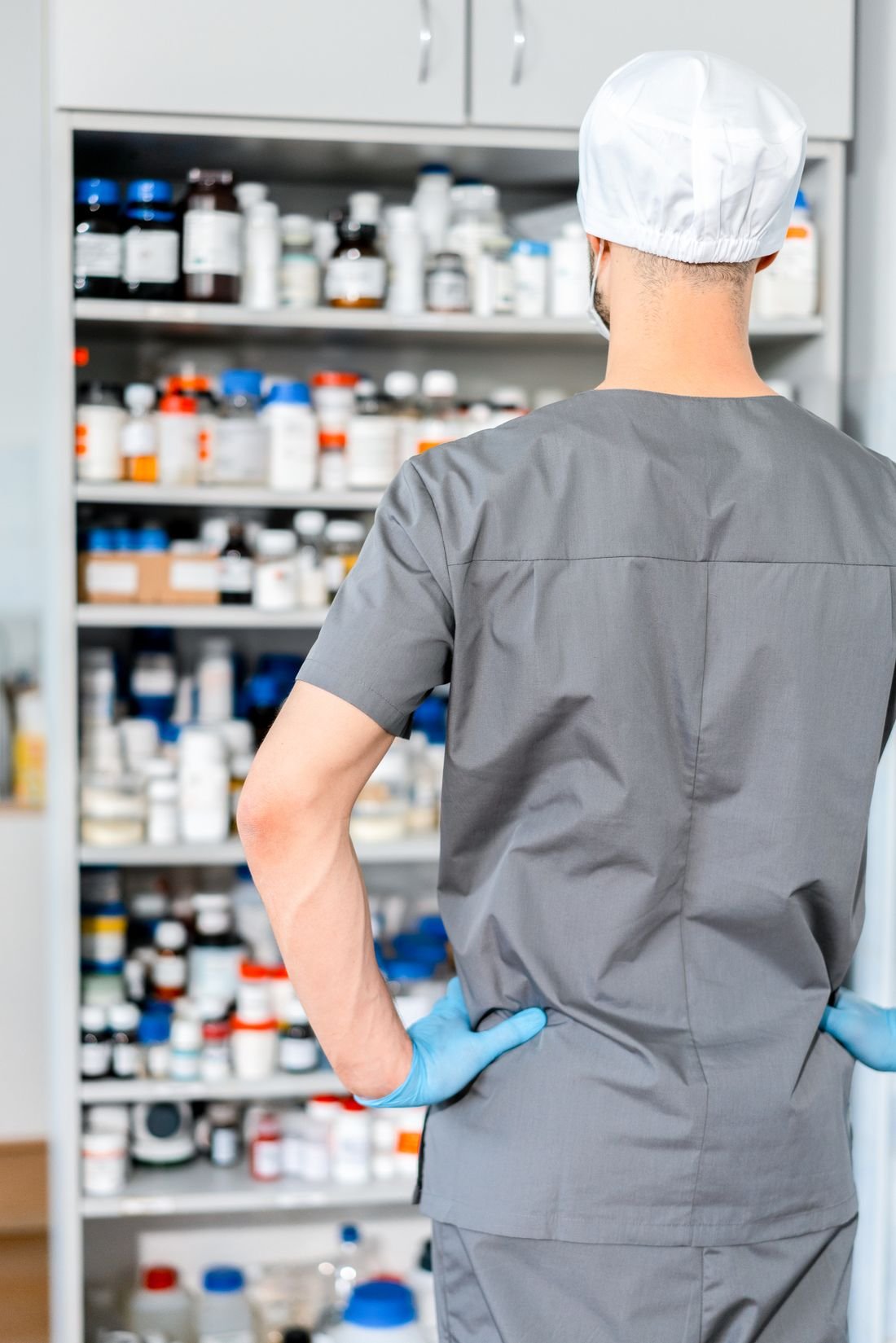 Auxiliar de farmacia frente a estantes con medicamentos