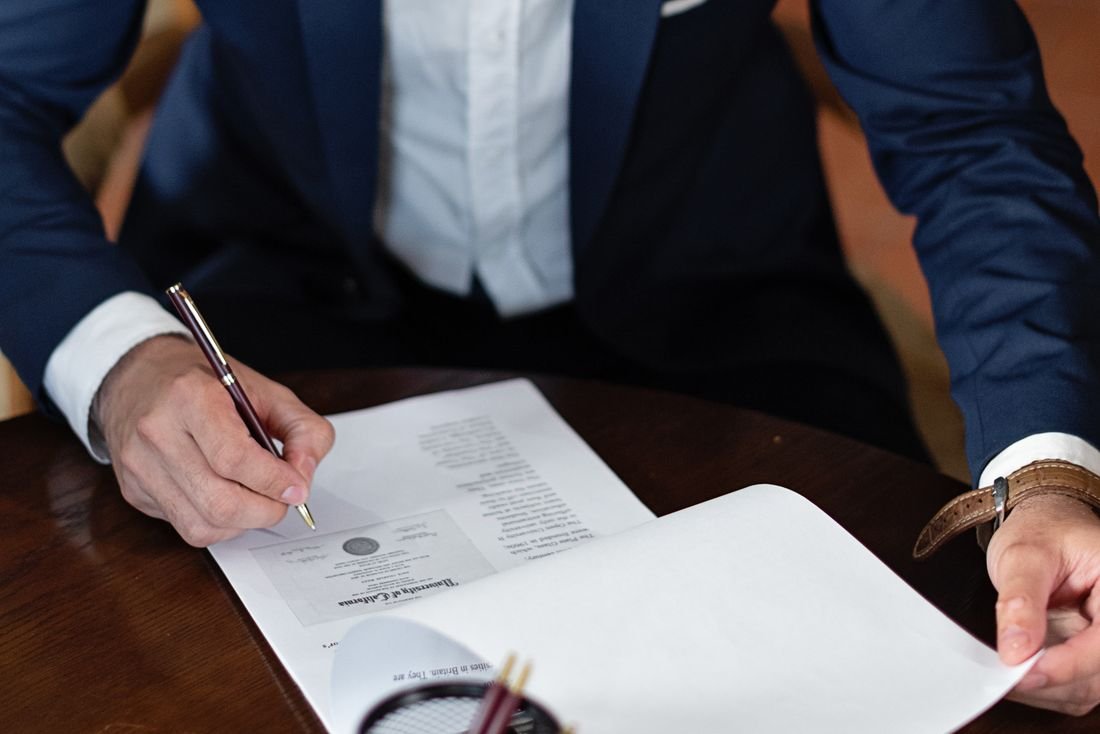 Documento legal formal siendo firmado sobre un escritorio