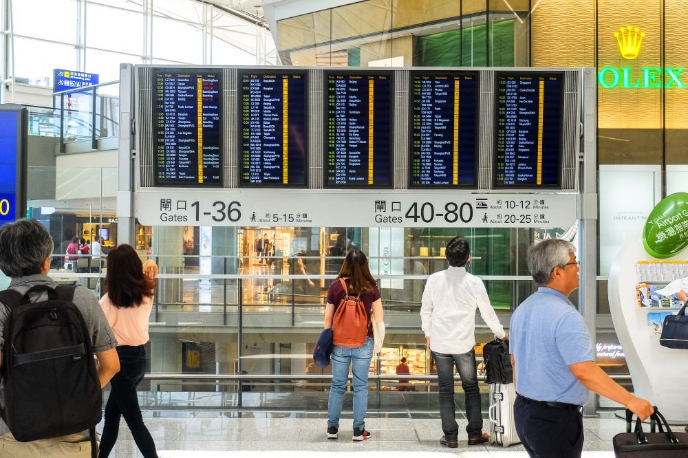Pasajeros consultando el tablero de vuelos en la terminal de un aeropuerto
