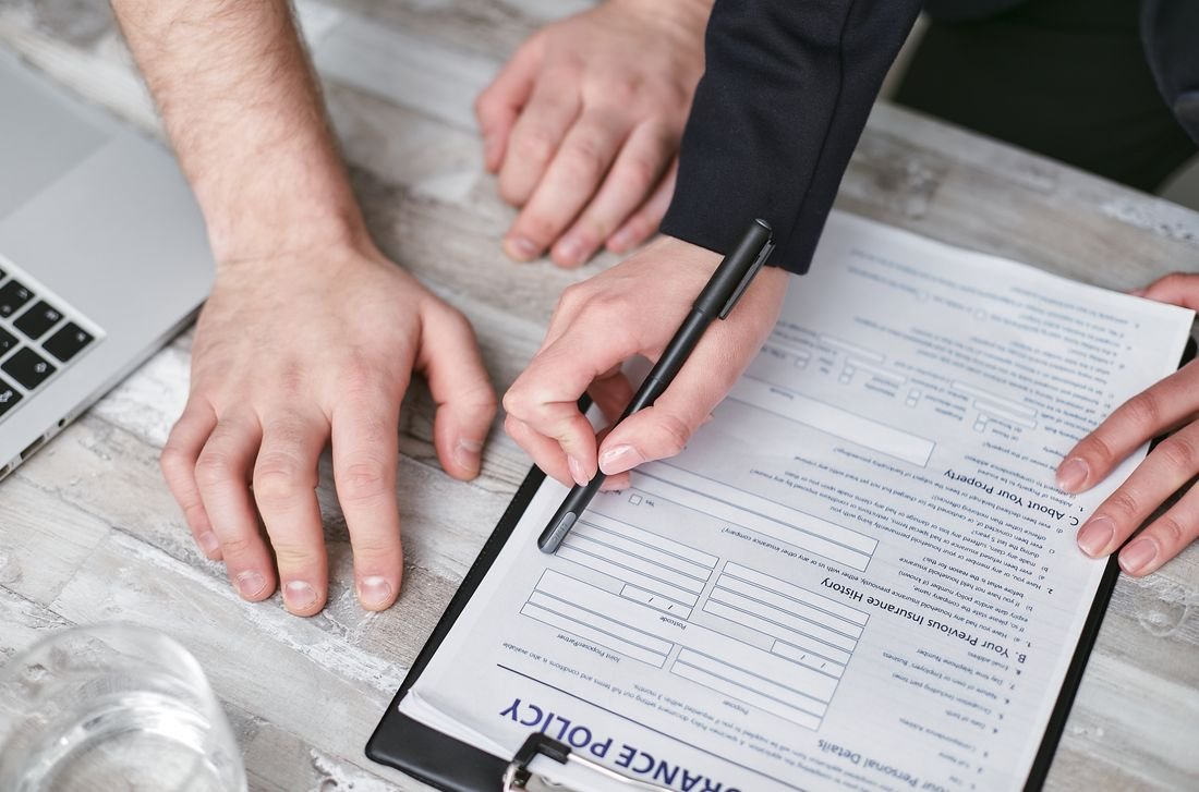 Dos personas revisando y firmando el formulario de una póliza de seguro