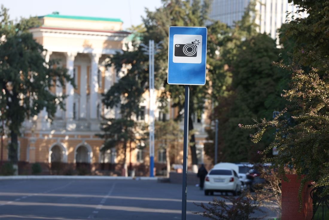 Señal de tránsito azul con el dibujo de una cámara que advierte una zona de fotodetección en una calle