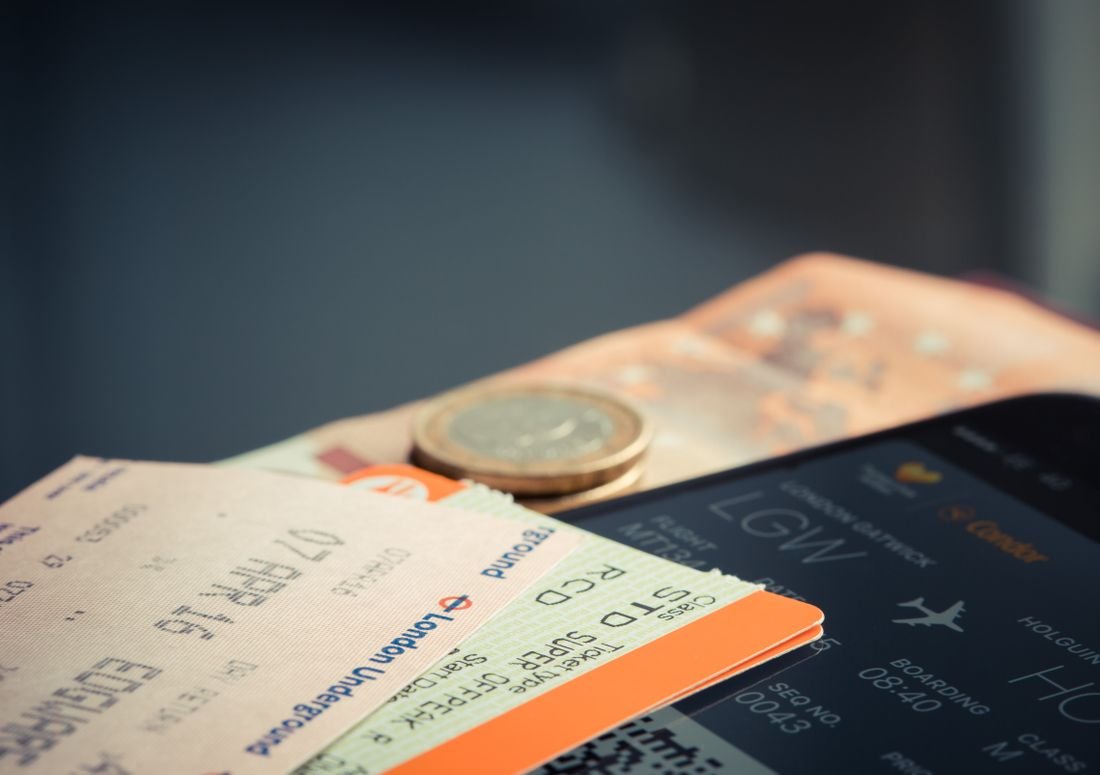 Pasabordos y tiquetes de viaje sobre una pantalla con información de vuelos