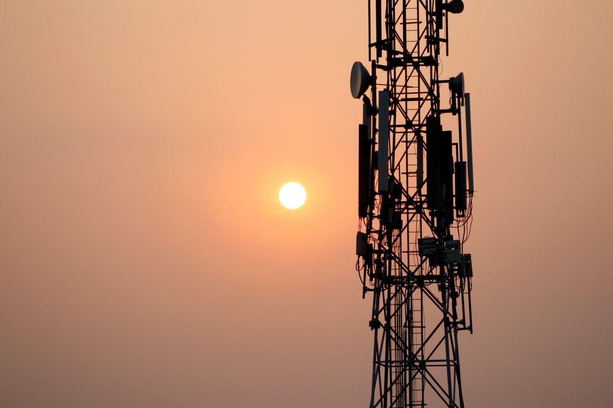 Silueta de una torre de telecomunicaciones recortada contra un cielo al atardecer